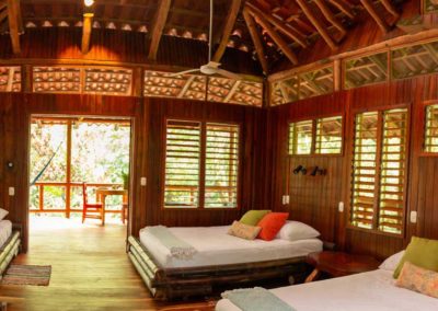 Olas 2 Beachfront Matapalo Suite with three queen beds, front and back patios, and hammock seating at a Luxury Family Beachfront Lodge Osa Peninsula